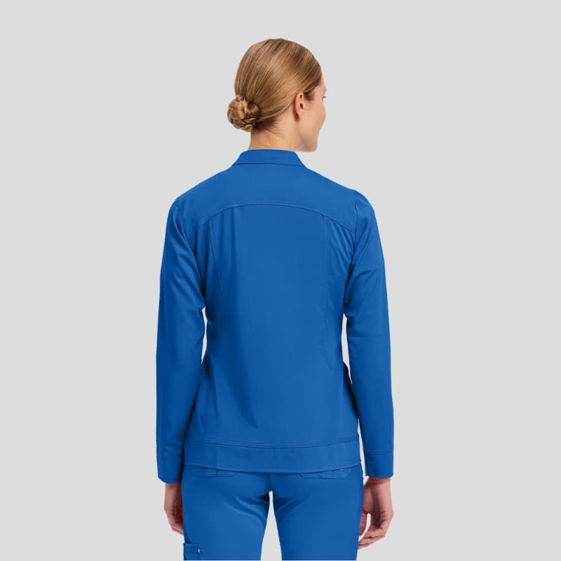 Woman wearing blue medical scrub set, back view, on plain background